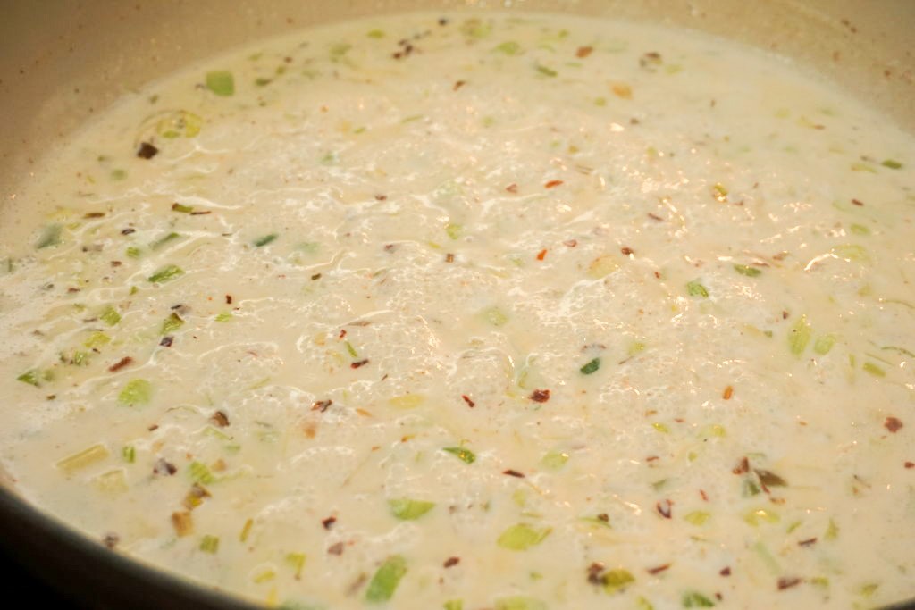 adding the seasoning and heavy cream to the skillet