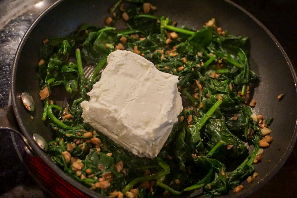 adding cream cheese to the spinach pan 