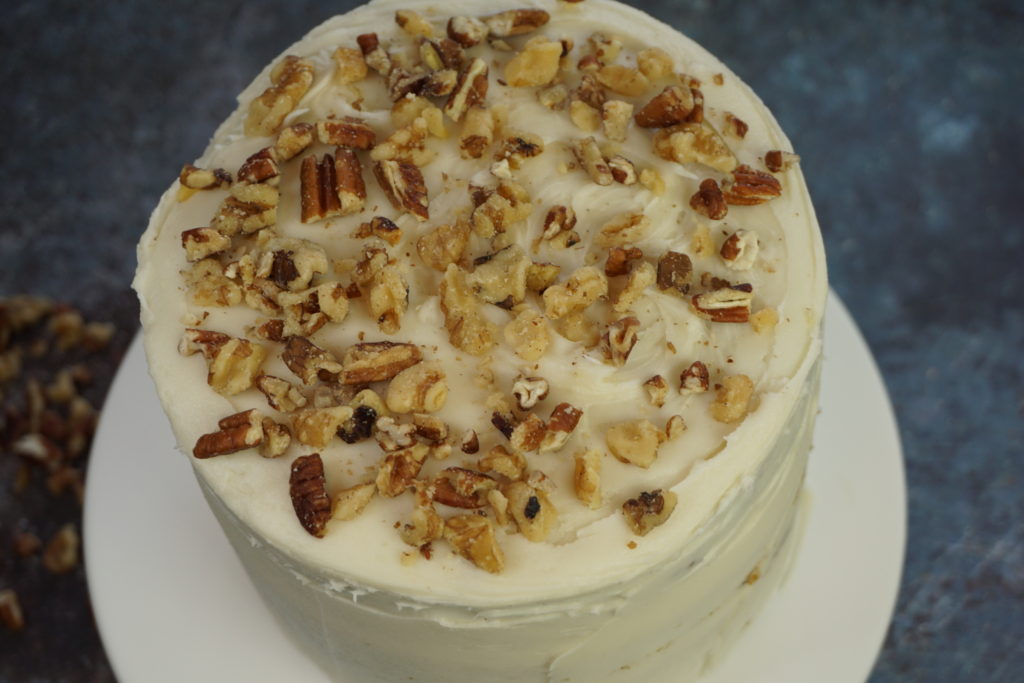 Whole cake of delicious carrot cake topped off with crushed walnuts and pecans. With a cream cheese frosting. 