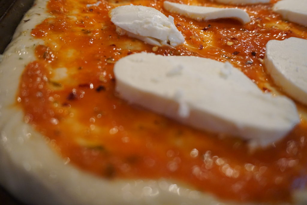 Tomato sauce with fresh mozzarella on top before baking 