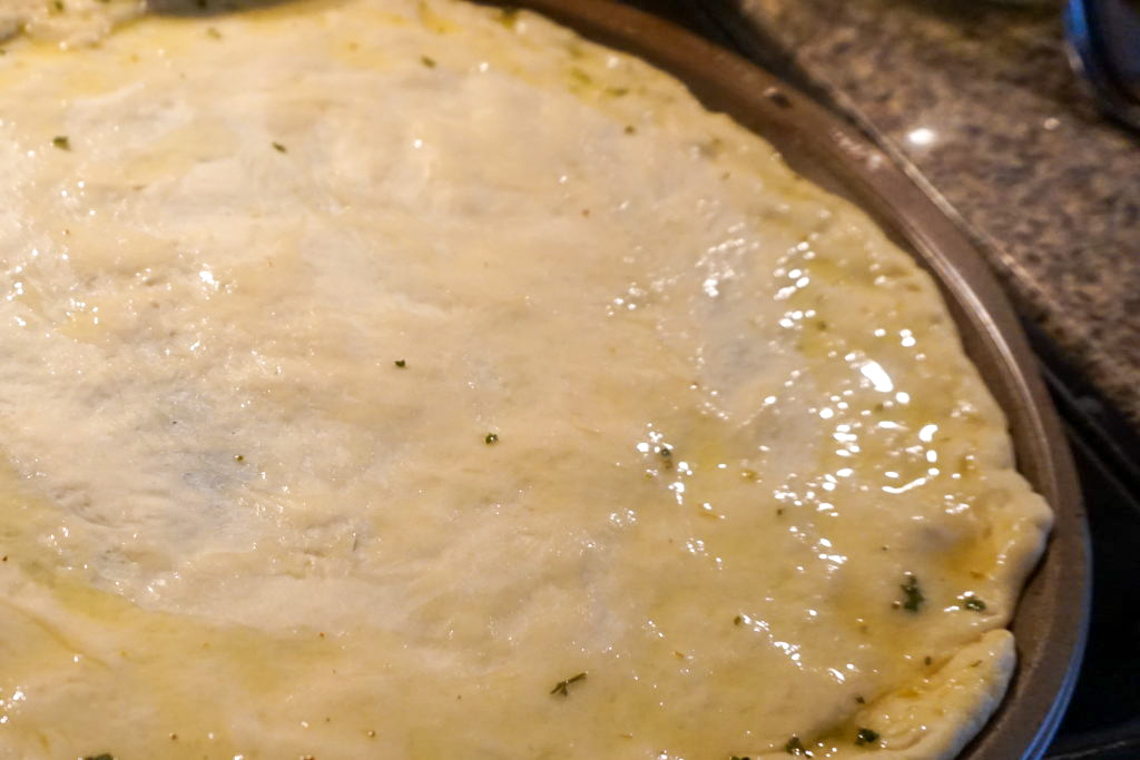 garlic herb sauce spread onto the pizza dough