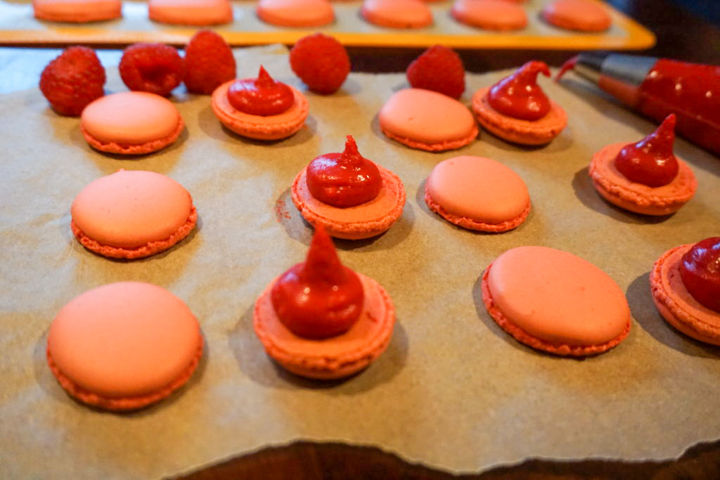 Filling the macaron shells with the raspberry ganache