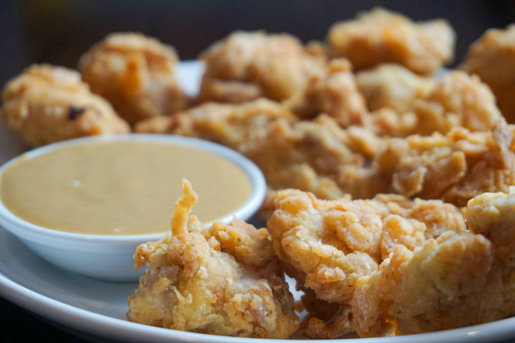 Close-up of crispy chicken nuggets with the Dulcet Scintilla sauce