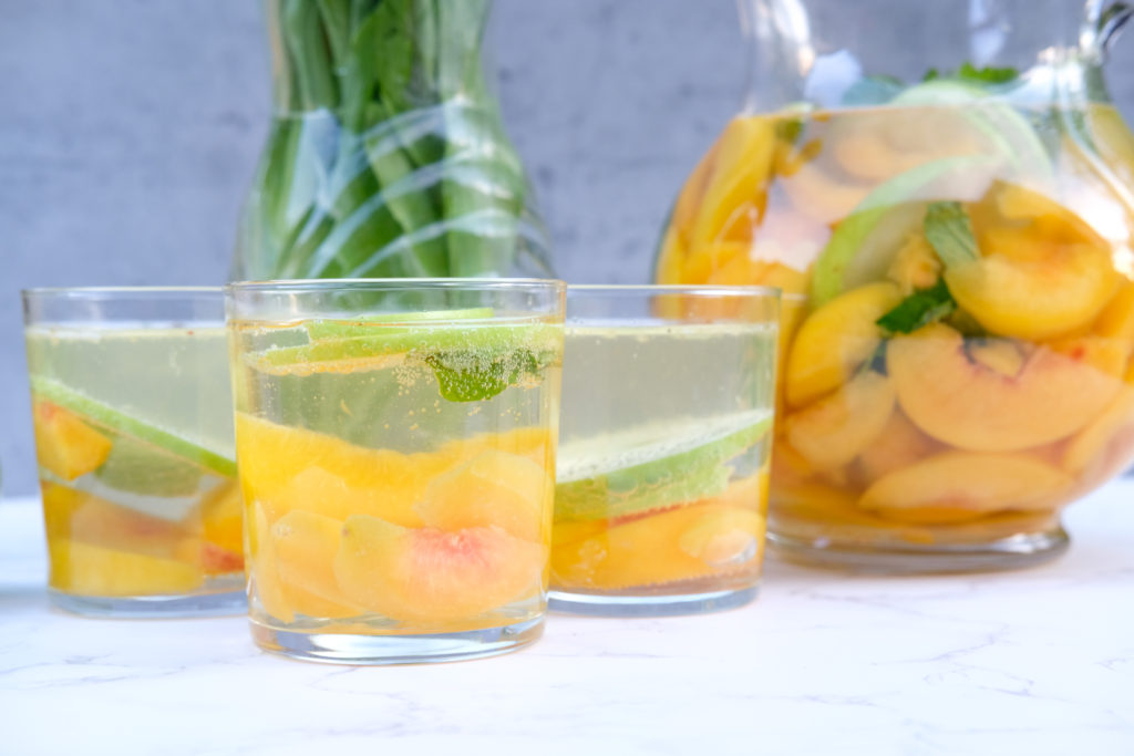 peaches and apples in glasses with wine and fresh mint