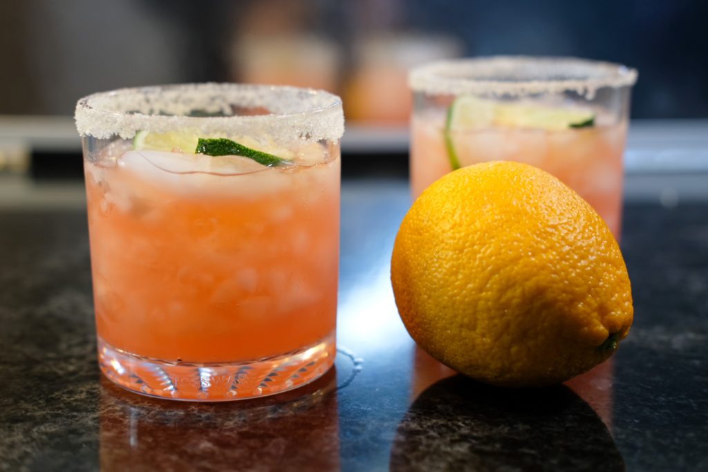 the blood orange margarita with a lemon and lime slices