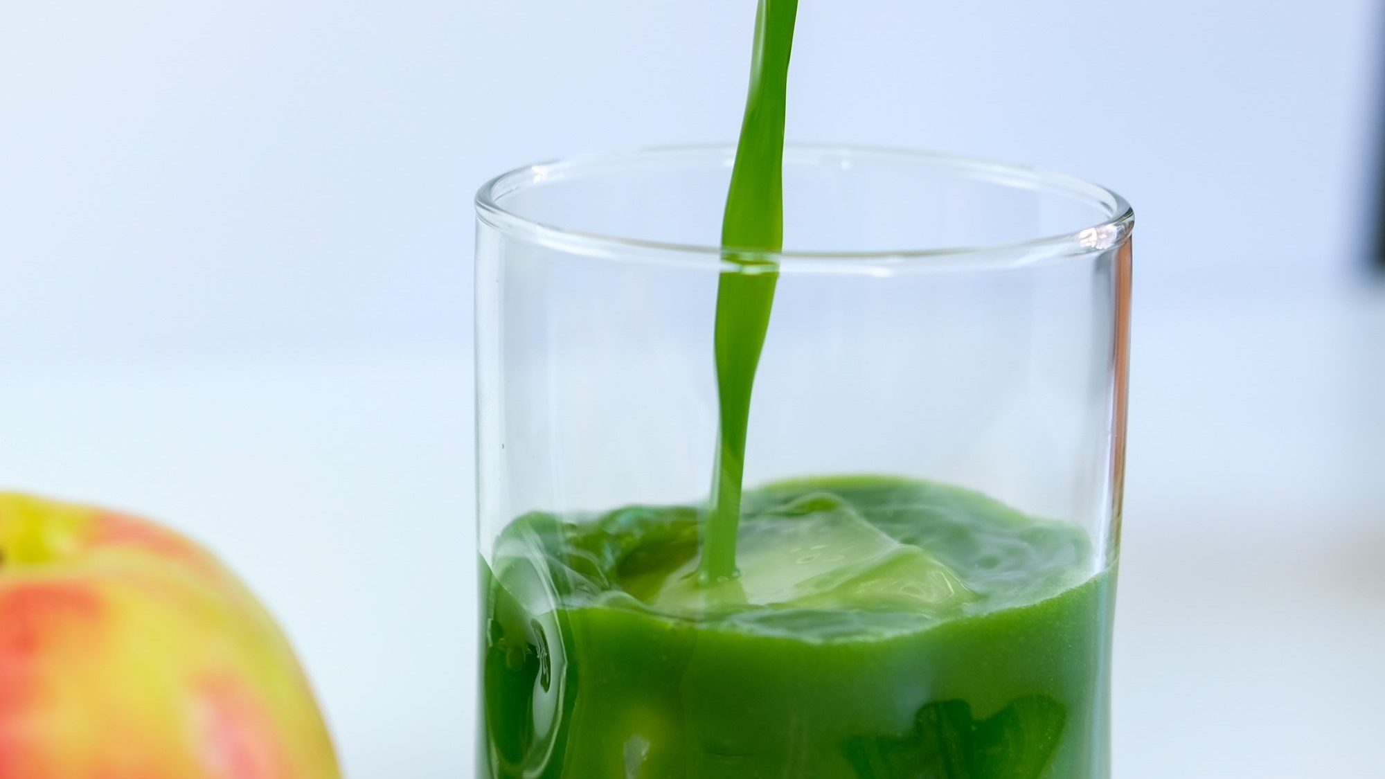 pouring the kale-ade into a glass with ice