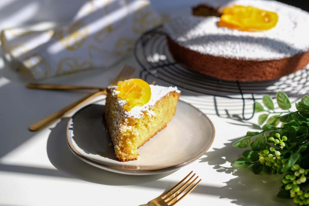 overview of the olive cake with a sliced piece of olive cake and candied oranges 