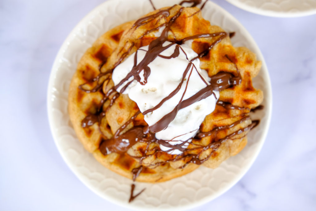 close-up of a vegan waffle with vegan whip cream and a chocolate sauce